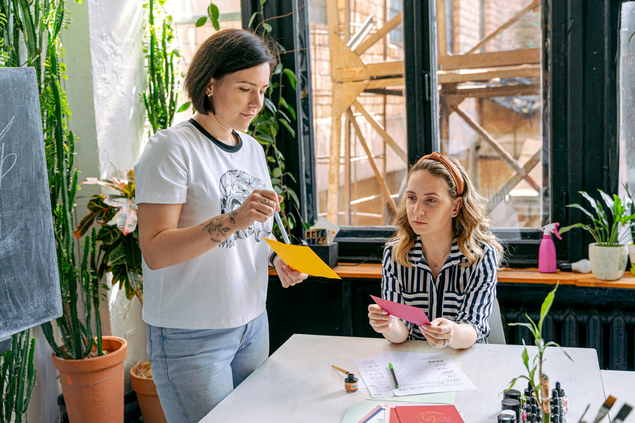 Art school instructors teaching students in a lively workshop setting.